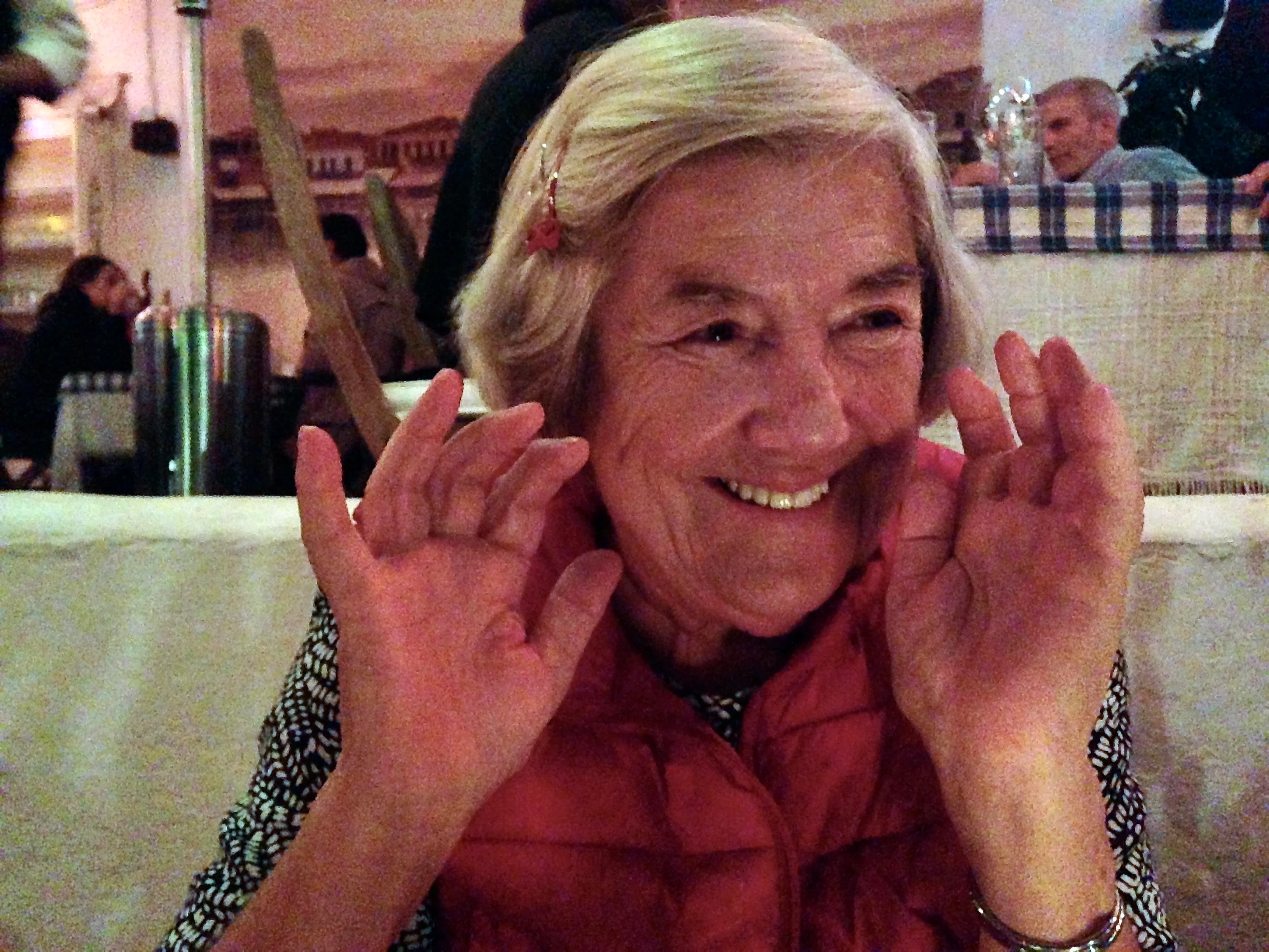 My mother smiling joyfully at a family dinner, full of life and energy